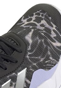 Sportliche Schuhe mit einem strukturierten Obermaterial aus schwarzem und grauem Stoff, das einen glatten Abschnitt aus schwarzem Leder, silberne Akzente und eine weiße Sohle aufweist.