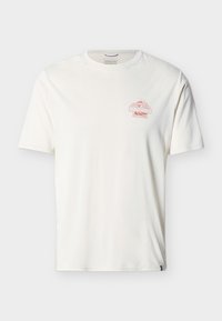 Άσπρο T-shirt με κοντά μανίκια, με μικρό κόκκινο λογότυπο Patagonia και γραφικό βουνό στο αριστερό στήθος, με μονόχρωμο φόντο.