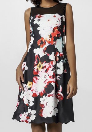 Robe sans manches noire à motifs floraux avec des fleurs blanches, rouges et roses, détails en maille aux épaules et un ourlet évasé avec un bord festonné.