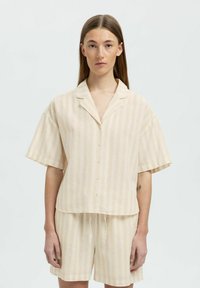 Kortærmet, knap-op skjorte og shorts sæt i lys beige med bløde lodrette striber; lavet af et let, tekstureret stof.