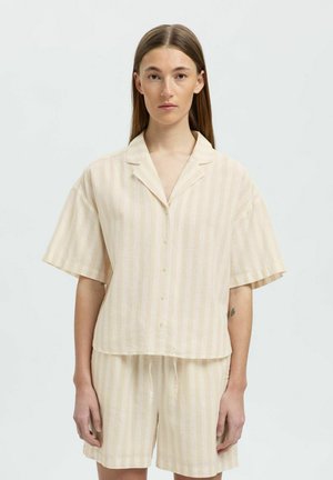 Kortærmet, knap-op skjorte og shorts sæt i lys beige med bløde lodrette striber; lavet af et let, tekstureret stof.