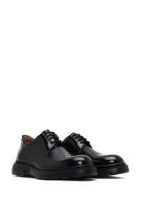 Chaussures noires en cuir à lacets avec une finition brillante, bout arrondi, col rembourré et semelle en caoutchouc épaisse pour une meilleure adhérence.
