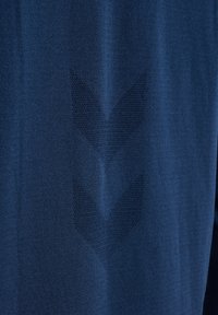 Mörkblå idrottströja med en texturerad tygkonstruktion och ett chevronmönster vävt i materialet. Slät och lätt design.