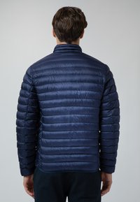 Giacca imbottita blu navy con texture trapuntata, dotata di un colletto alto e strisce orizzontali sottili. Il tessuto appare liscio e leggero.