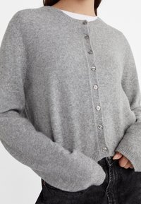 Gray knitted cardigan with a rounded neckline, button-front closure, and long, slightly loose sleeves, made from a soft wool blend.