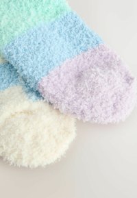 Flauschige, mehrfarbige Socken, die aus hellgrünen, blauen, lavendelfarbenen und cremfarbenen Abschnitten bestehen. Weiche Textur mit gerippten Akzenten an den Bündchen.