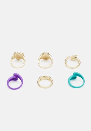 Um conjunto de seis anéis: três anéis de metal dourado com formas e designs variados, um anel curvo roxo e um anel curvo turquesa.