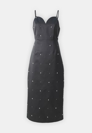 Vestido negro ajustado con escote en forma de corazón, tirantes finos y adornos metálicos dispersos en una tela con textura.