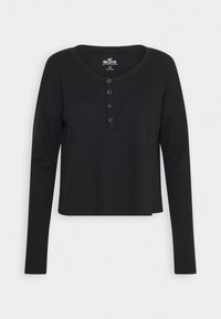 Svart långärmad ribbad stickad crop top med rund halsringning och fyra knappar, Hollister-varumärkesetikett inuti kragen.