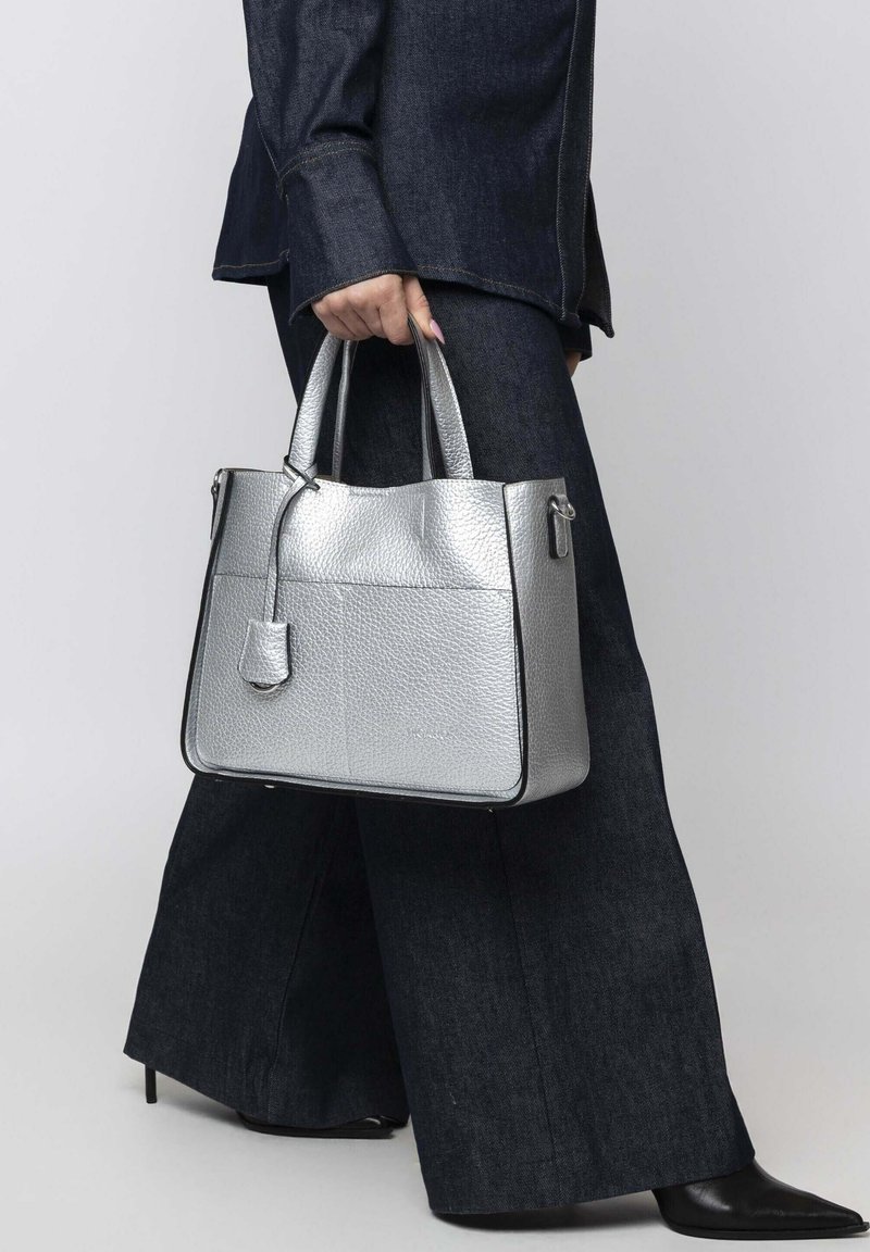 Silberne Handtasche mit strukturiertem Lederfinish, rechteckiger Form, zwei Obergriffen und einem passenden abnehmbaren Etikett.