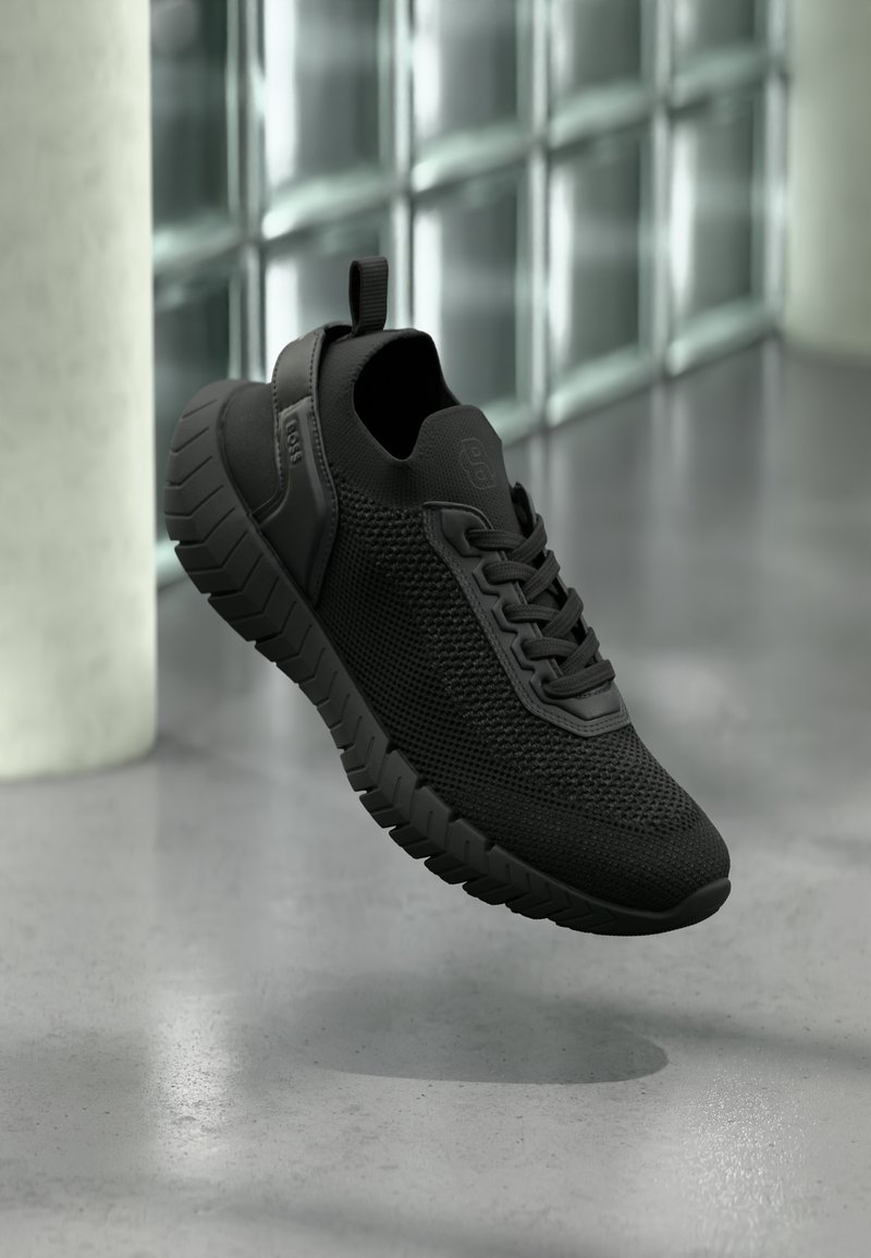 Μαύρο αθλητικό παπούτσι με υφασμάτινο επάνω μέρος με υφή, λαστιχένια σόλα και θηλιά στο πίσω μέρος. Διαθέτει μοντέρνο σχέδιο και κορδόνια.