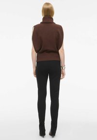 Brun ærmeløs turtleneck sweater med ribbet kant, parret med sorte tætsiddende bukser. Sættet har en glat overflade og kropsnær pasform.