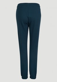 Námořnické modré tepláky vyrobené z bavlněné směsi, s elastickým pasem a přiléhavými manžetami. Hladký povrch bez viditelných vzorů.