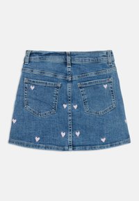 Denim A-line krilo, svetlo modro z rožnato vezenimi srčki. Ima dve zadnji žepki in pas z zankami za pas. Priložnostna zasnova.