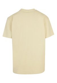 T-shirt a maniche corte in beige chiaro, materiale in cotone. Collo rotondo, design semplice con vestibilità rilassata e senza motivi o grafica visibili.