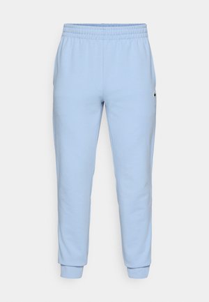 Lichtblauwe sweatpants van zacht materiaal, met een elastische tailleband en aansluitende boorden. Bevat een klein logo aan de zijkant.