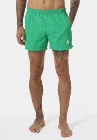 Zelené plavky z lehkého materiálu, s elastickým páskem, postranními kapsami a malým logem na dolním levém rohu.