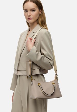 Beige Ledertasche mit goldenen Beschlägen, runder Form, kurzen Griff und langem Tragegurt. Begleitet von einer kleinen passenden Geldbörse.
