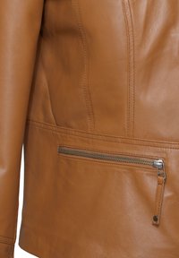 Braune Lederjacke mit strukturiertem Finish, schlankem Design und einer mit silbernem Zubehör versehenen Reißverschlusstasche.