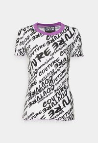White short-sleeve t-shirt with black "COUTURE" and "versace jeans" text patterns and purple ribbed neck and sleeve edges.