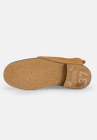 Suela de goma de un zapato marrón claro, texturizada con una superficie de agarre con patrones; talón marcado con la talla 37 y el nombre de la marca.