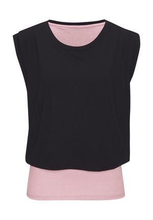 Ärmelloses, schwarzes Crop-Overlay-Top, das über einem hellrosa, enganliegenden, ärmellosen Shirt mit rundem Ausschnitt getragen wird.