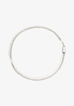 Kolmehaarainen kaulakoru, jossa vuorottelevat pienet valkoiset helmet ja hopeapallot. Tyylikäs metalliklipsi näkyy, lisäten modernia ilmettä.