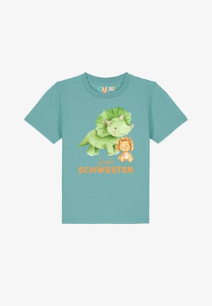 Lichtblauw katoenen T-shirt met een groene dinosaurustekening en een bruine leeuw, met de tekst "Große Schwester" in oranje.