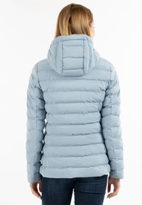 Chaqueta de plumas azul claro con un diseño ajustado, textura acolchada horizontal y capucha, que presenta puños elásticos y un dobladillo ligeramente curvado.