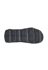 Suola di scarpa in gomma nera con texture rigata, caratterizzata da scanalature orizzontali e verticali per trazione e stabilità.