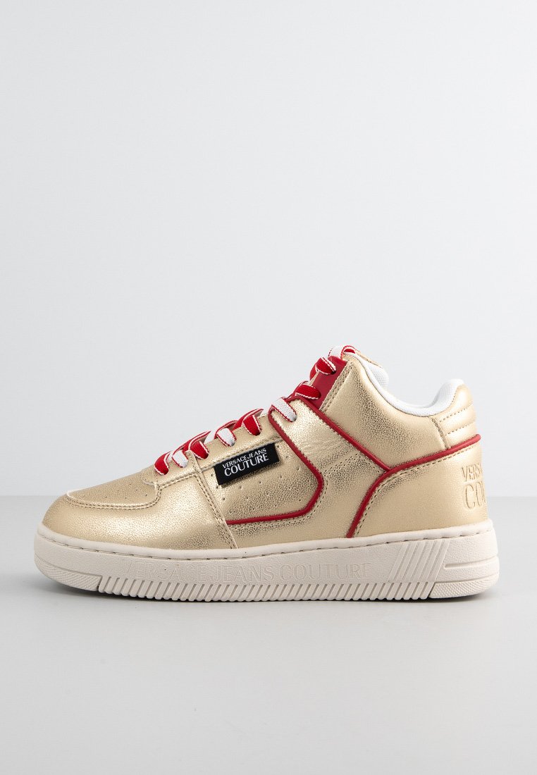 Sneaker in pelle dorata con lacci rossi, colletto imbottito e logo in rilievo sul lato. Suola in gomma con battistrada testurizzato per una migliore aderenza.