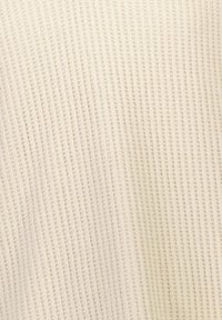 Tessuto testurizzato con righe verticali di un colore crema chiaro. Texture morbida con una leggera lucentezza e modelli alternativi di sezioni in rilievo e piatte.