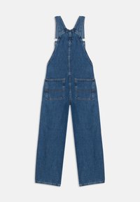 Pantalones de mezclilla azul de pierna ancha con bolsillos frontales y tirantes ajustables, dispuestos sobre un fondo blanco.