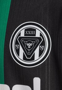 Zwart gestreept shirt met een ronde logo met een driehoekig ontwerp en de tekst "XXIII." Het logo bevat gestileerde ogen en accenten in het wit.
