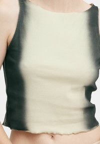 Ribbade linnen med en gradientdesign från ljus beige till mörkgrå. Kragen är något trasig, vilket ger textur åt plagget.