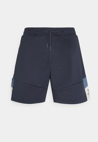 Lautan biru celana pendek atletik pria dengan tali pinggang dan panel miring berwarna biru muda serta putih di sisi-sisinya.