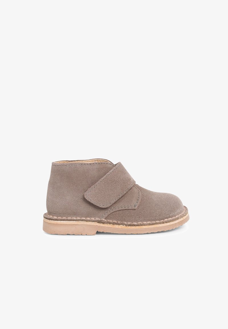 Gray suede ankle boots with a wide Velcro strap and natural rubber sole, featuring a stitched detailing along the sole edge.