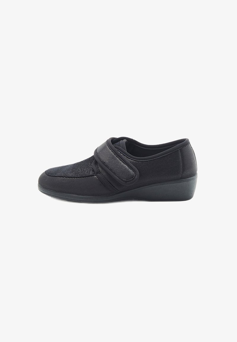 Scarpe slip-on nere con tomaia in tessuto testurizzato, cinturino regolabile in velcro e tacco basso per maggiore stabilità.