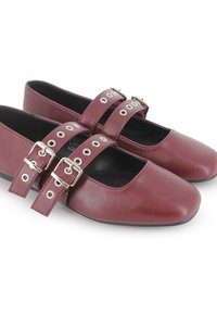 Pareja de zapatos Mary Jane burdeos con doble correa y hebillas plateadas, interior negro y suelas planas bajas.