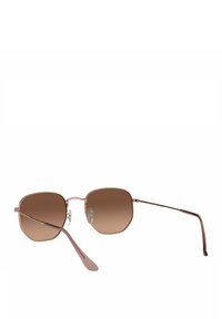 Gafas de sol con una forma octagonal geométrica, lentes de degradado marrón, montura de metal fina y un acabado brillante en oro rosa. Incluyen almohadillas nasales ajustables.