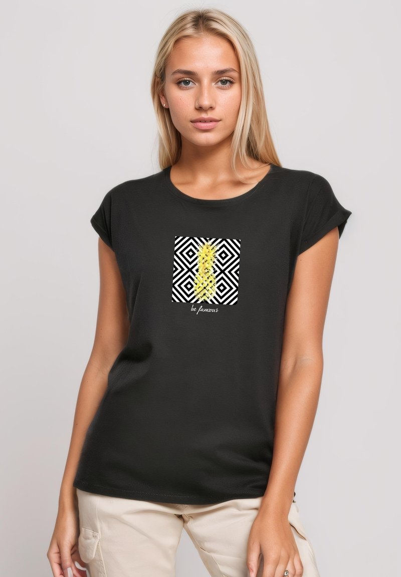 Black short-sleeve t-shirt featuring a square graphic with yellow and black geometric patterns, text reading "be famous" at the bottom.
