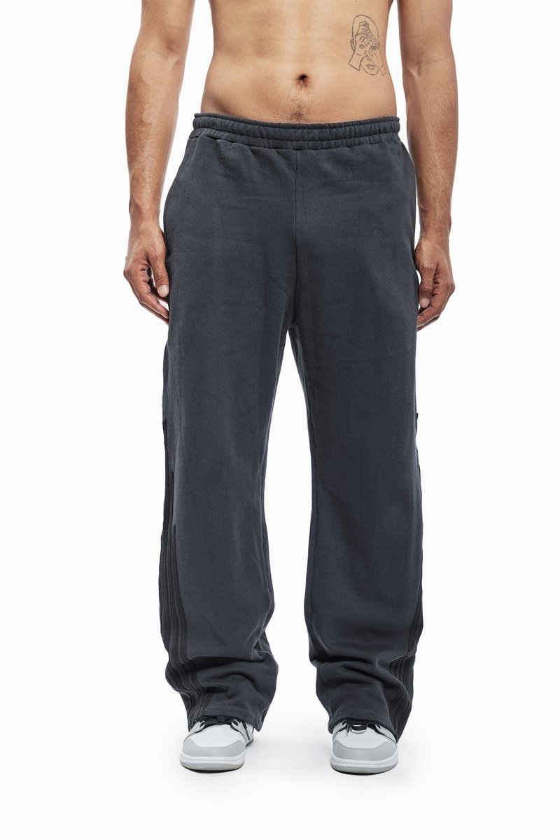 Grå joggingbukser lavet af blødt stof, med elastisk talje, sidelister og en afslappet pasform. Sæt sammen med hvide sneakers.