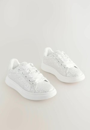 Hvide glitrende sneakers med glatte hvide snørebånd, en afrundet tå og subtil polstring på kraven og tungen. Gummisål.