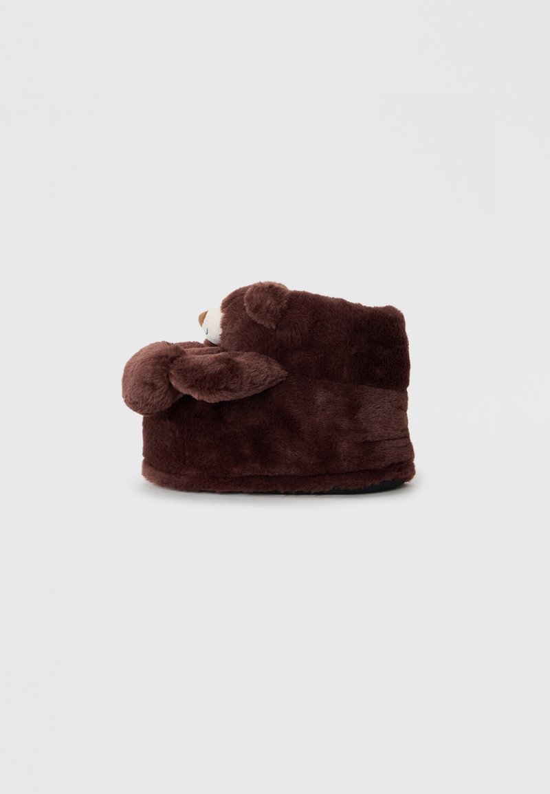 Brown plush bear-shaped slipper with rounded shape, soft texture, and ear accents. Features a fabric sole for indoor use.