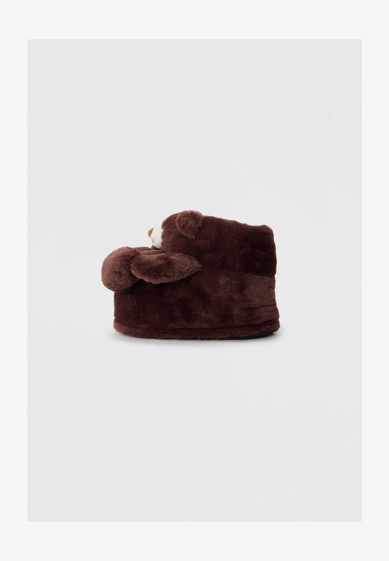 Brown plush bear-shaped slipper with rounded shape, soft texture, and ear accents. Features a fabric sole for indoor use.