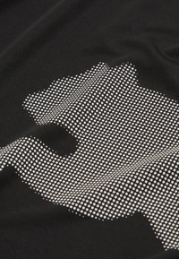 Tela negra con un gran gráfico de huella de pata en blanco punteado, con una textura suave y un diseño moderno.