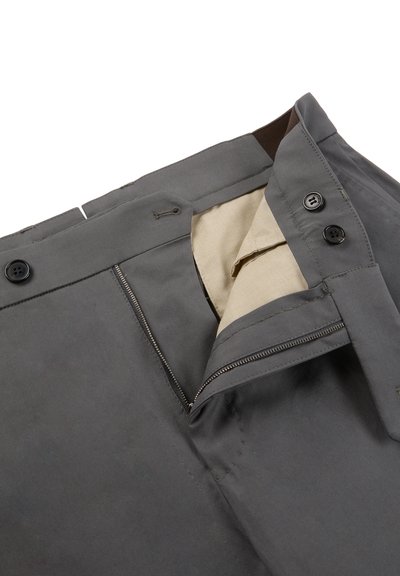 Pantalon gris foncé avec fermeture éclair ouverte, doublure de poche beige et bouton de fermeture sur fond blanc.