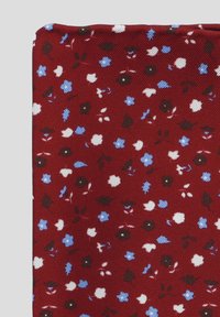 Czerwona tkanina z kwiatowym wzorem, na którym znajdują się małe białe, niebieskie i czarne kwiaty. Teksturowana powierzchnia o miękkim, tkanym wyglądzie.