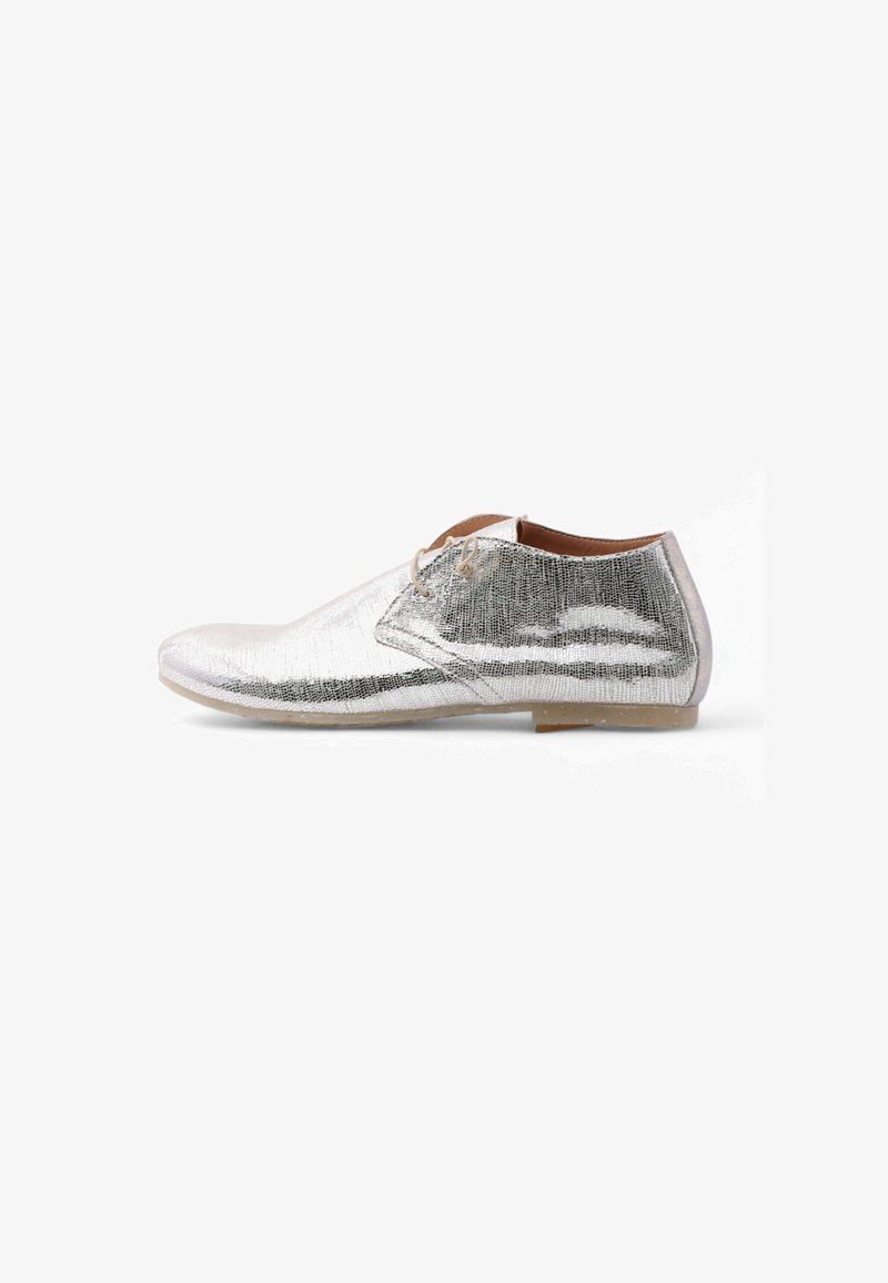 Zapato de vestir plateado con un acabado metálico texturizado, punta redondeada, dos ojetes para los cordones y una suela de goma beige.