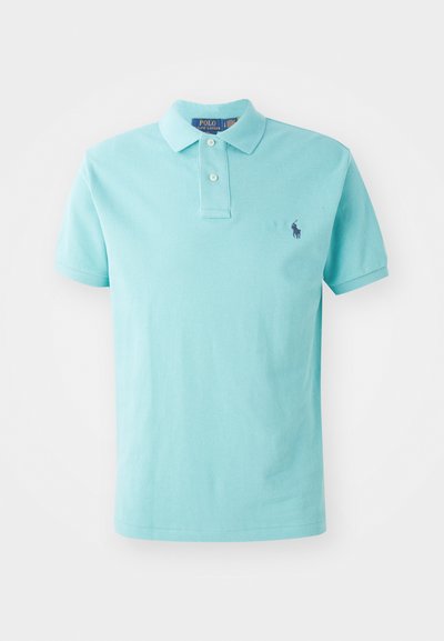 Ljusblått polo-shirt i bomull med klassisk krage, tre-knappslås och en liten marinblå logotyp på vänster bröst.